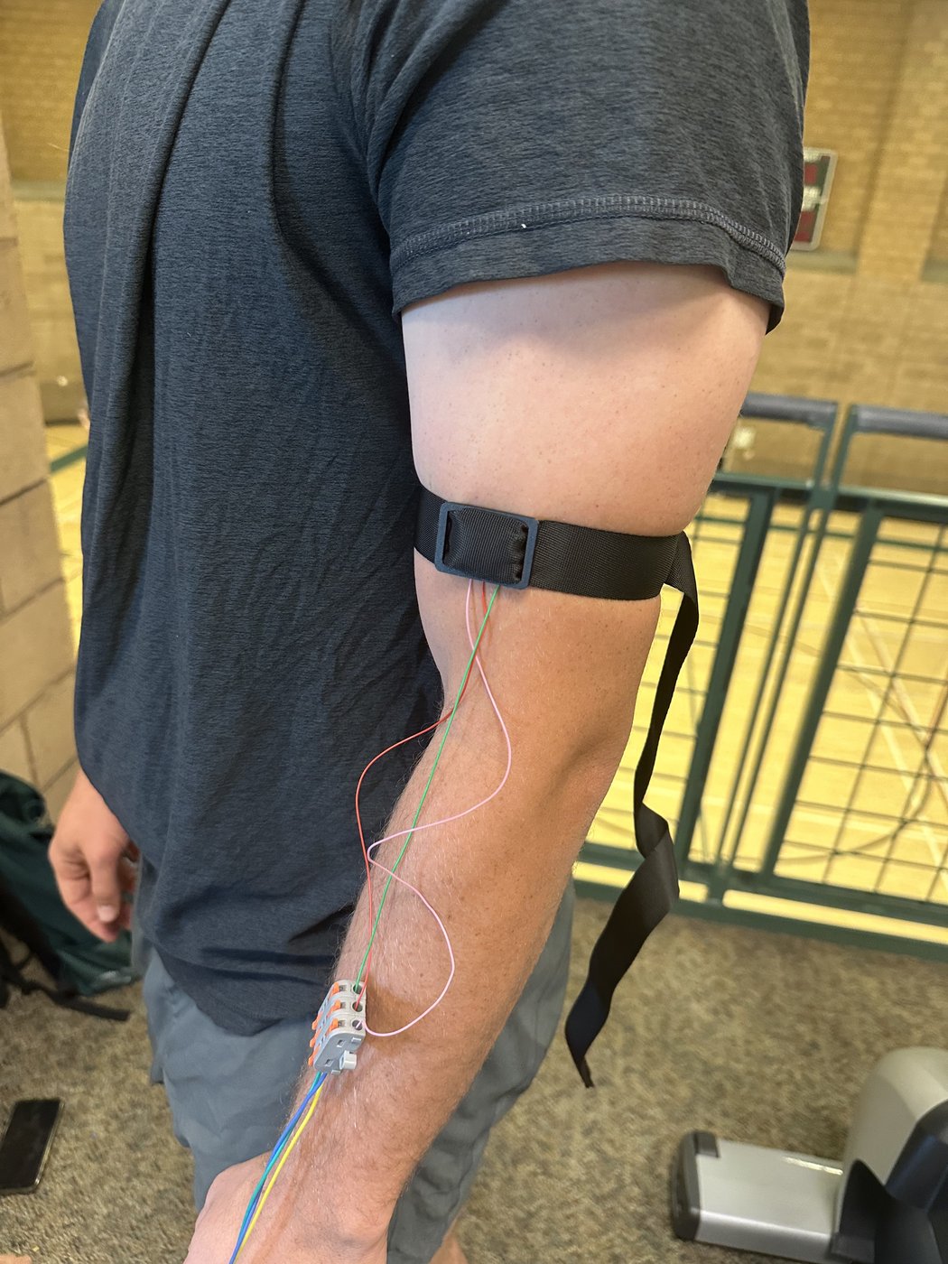 The finished sensor, worn for a real test — electrode band on the arm, leads run down to the potentiostat.