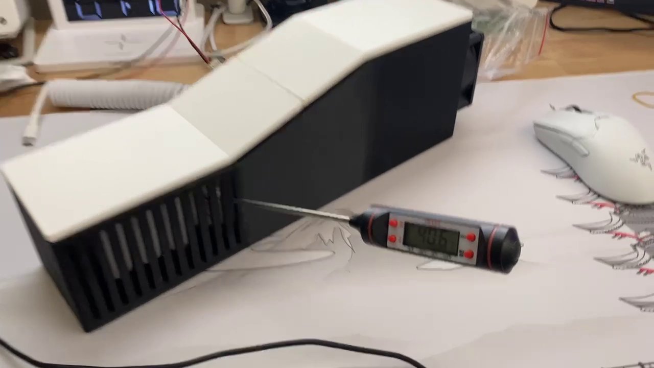 The physical build, closed — probe thermometer reading 40.5°C through the vents mid-test.