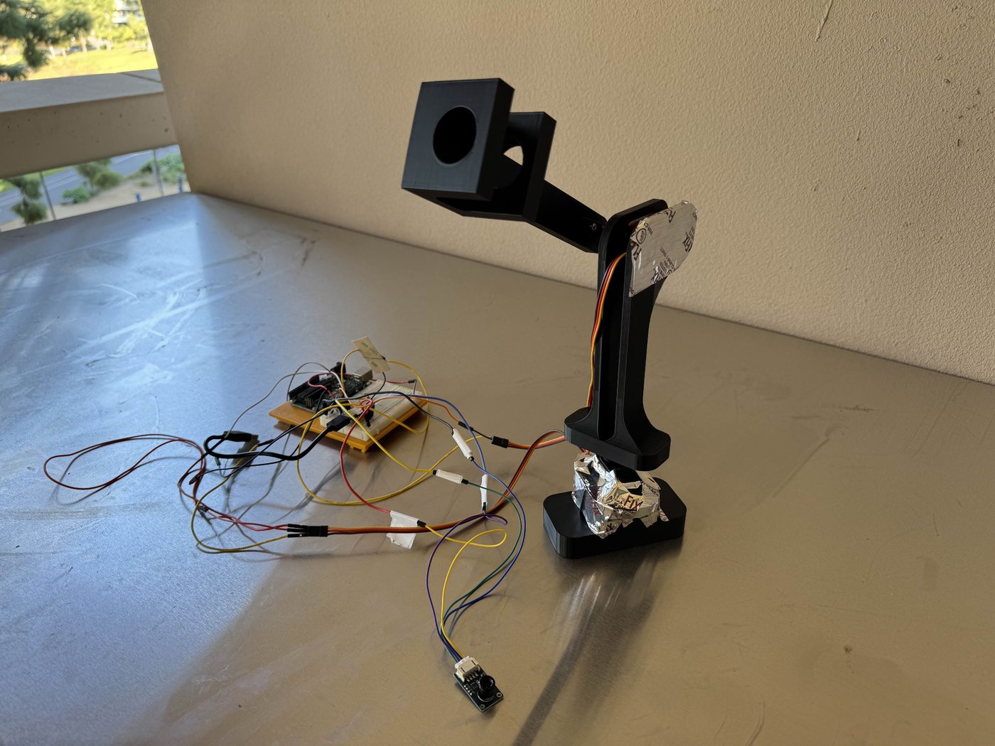 The bench prototype — gimbal head, thermal camera, and breadboard electronics.